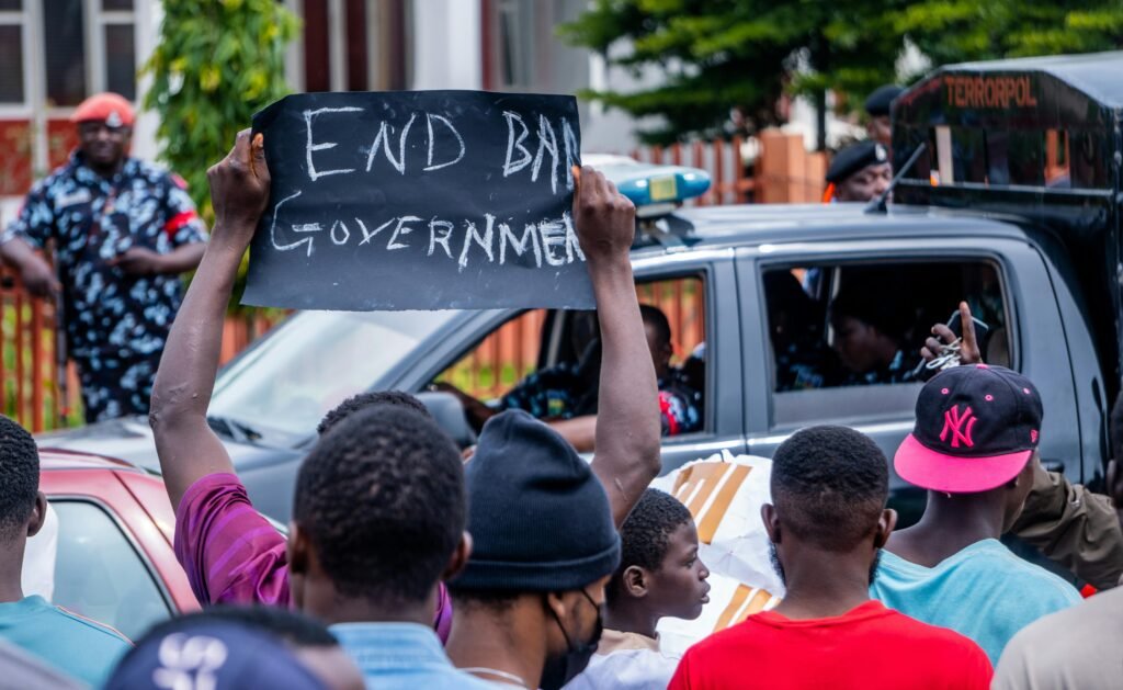 Protesters holding a sign demanding change in Nigeria during a peaceful demonstration.