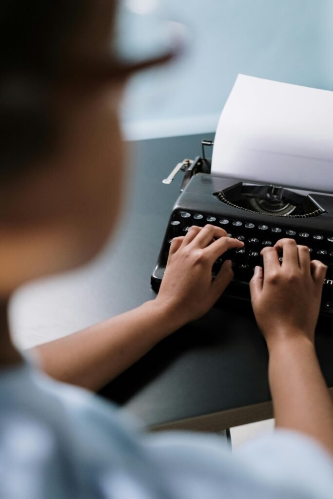 Close-up of hands typing on a vintage typewriter, creating nostalgia.