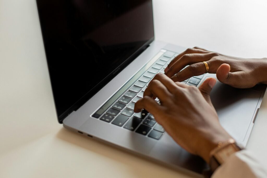 Hands typing on a laptop keyboard during a work session, showcasing modern connectivity.